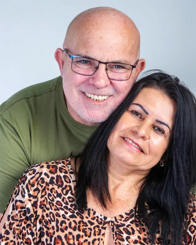 Casal sorridente abraçado em ensaio de estúdio