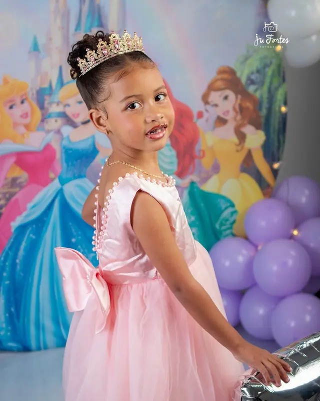 Menina com coroa e vestido rosa em ensaio temático de princesas