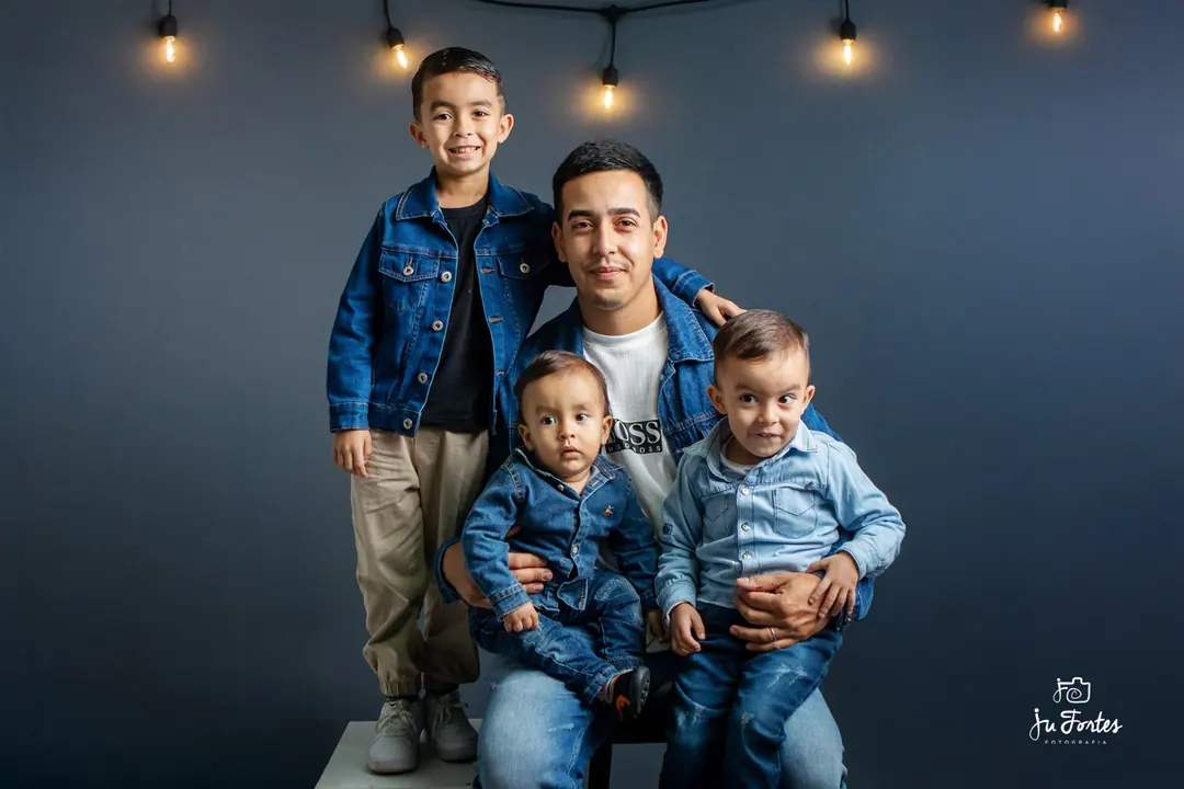 Pai com três filhos vestidos de jeans em ensaio de família